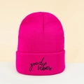 Close-up of black 'good vibes' embroidery on a rose red ribbed knit beanie hat - Rose Red
