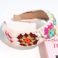 Close-up of handmade knitted headband with colorful floral embroidery on beige wool - Colorful Square Knotted