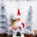 Detail of plush Santa Claus doll with gift bag and bell beside snowy Christmas trees - 5 Inch New Red Print Style