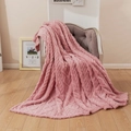 Pink 3D cable knit fleece blanket with soft texture draped over a vintage armchair - Rose Pink