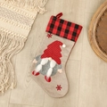 Christmas gnome stocking with red polka dot hat and buffalo plaid cuff on wood floor - Dotted Pattern