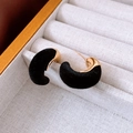 Detail von eleganten schwarzen Samt- und vergoldeten C-Ohrringen in einer Schmuckbox - Schwarz