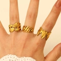 Detailed view of three golden irregular plant-shaped rings worn on a hand - Leaf 3-Piece Set