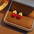 Makroaufnahme roter Blumenohrstecker mit Vergoldung und Zirkon in einer Schmuckschatulle - Rote Perle mit Goldener Krone