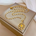 Detail of gold starburst necklace with yellow center stone on champagne jewelry box - Geometric Star Style (J434)