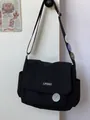 Japanese style black canvas messenger bag with flap closure and decorative pins - Black