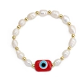 Detail of freshwater pearl bracelet with golden beads and red evil eye charm pendant - Red