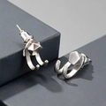 Macro detail of silver geometric hook earrings on a grey architectural background - Pentagon + Ear Hook Pair