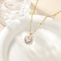 Macro detail of gold heart pendant with sparkling pavé cubic zirconia on ceramic edge - White Pendant Necklace