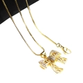 Close-up of golden bow pendant with micro-set zircons and a classic box chain necklace - Pendant And Necklace (1)