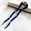Detail van golvende U-vormige acetaat haarspeld met blauwe en bruine marmertextuur op doek - Blauw