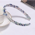 Detail of floral headband with blue and green stones and small pearls on a white desk - Navy Blue Headband