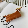 Dettaglio del fermaglio per capelli a capra in acetato con corna dorate su una rivista - Yak / Circa 7cm