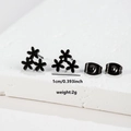 Macro view of black stainless steel floral stud earrings showing 1cm size and 2g weight - Flower (072) / Black