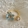 Détail d'une perle baroque et d'une fleur en émail bleu sur une bague torsadée dorée rétro - Or 18K [Fleur bleue]