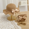 Détail d'un chapeau de paille avec nœud en satin et mini sac à bandoulière pour enfant - Chapeau Kaki + Sac