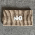 Macro detail of camel knitted sports headband with HO embroidery and ribbed texture - Khaki