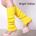 Close-up of bright yellow ribbed knit leg warmers paired with pink high heel sandals - Bright yellow