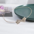 Eleganter goldener Metall-Haarreif mit einer Kristall-Schleife auf weißem Hintergrund - Goldener Stil (C9518)