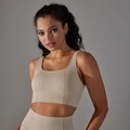 Gros plan d'une brassière de sport beige avec un tissu en maille gaufrée extensible - Beige