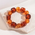 Primer plano de pulsera de cuentas acrílicas ámbar con cuentas texturizadas en piedra blanca - Café Oscuro