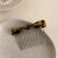 Elegant tortoise shell bow hair comb with gold wire teeth on a decorative ceramic plate - Dark Tortoiseshell