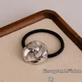 Silver metallic knot hair tie with black high-elastic band on walnut tray - Twist Knot Silver