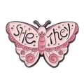 Detailed view of pink enamel butterfly pin featuring She and They pronoun identifier text - She-They Pronoun Pink Butterfly