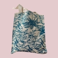 Detail of beige woven tote bag with teal Toile de Jouy pattern and dual carry handles - Blue Coconut Tree