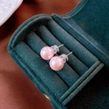 Primer plano de pendientes de perlas rosas con postes de plata en caja de terciopelo verde - Pin de Plata S925 / Perla Rosa 9mm