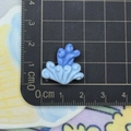 Macro shot of a 2cm blue ocean wave resin charm on a metric scale cutting mat - Sea Wave