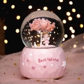 Pink Sakura snow globe music box with girl figurine and warm bokeh background lighting - Medium 80 Light + Music / Standing Prayer Girl