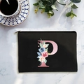 Black canvas cosmetic bag with pink floral letter P on white marble background - Letter P