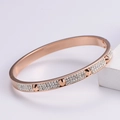 Detailed view of rose gold nail bracelet featuring pavé crystals and pointed studs - Rose Gold