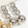 Macro detail of high-polish metal spheres on chain earrings in gold and silver finish - Copper Ball Stud Real White Gold