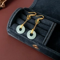 Makroaufnahme von 18K Gold Schmetterlingsohrringen mit hellgrünen Jadetyp-Ringanhängern - Ohrhaken Schmetterling Stil / Gold-Grün