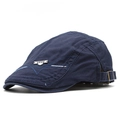 Detalle de gorra plana de algodón azul oscuro con emblema metálico y hebilla ajustable - Azul marino