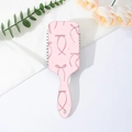 Dettaglio della spazzola per capelli rosa con fiocchi su sfondo bianco con fiori - Fiocco Lungo