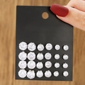 Set of 12 pairs of silver-toned zircon stud earrings in various sizes on black card - 12 Pairs Silver Round Zirconia Set (E1787-1)