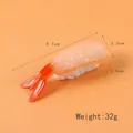 Modèle de sushi aux crevettes artificiel réaliste pour vitrine, longueur 9,7cm sur fond orange - Sushi à la Queue de Crevette
