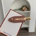 Floral duckbill hair clip in brown resin with gold star and pink rhinestones on a card - Nude Pink Star