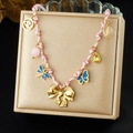 Collier bohème plaqué or avec pendentifs papillons et nœuds colorés dans un écrin à bijoux - Style Pendentifs Multiples Nœud Papillon Doré Corde Tressée Rose (N3805)
