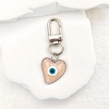 Close-up of heart-shaped evil eye keychain with pink quicksand texture and silver clip - Pink Heart (Silver Keychain)