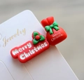 Macro detail of red Merry Christmas hair clips with holly and gift bag design - Style 35 Christmas Hair Clip