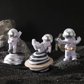Set di 3 figurine di astronauti bianchi con caschi argentati su superficie spaziale - Un Set Argento Interstellare