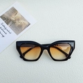 Cat eye sunglasses with black frames and orange gradient lenses in a stylish flat lay - Black Frame Sunset Yellow