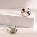 Minimalist silver titanium wave earrings with polished organic texture on a white base - Wrinkled Circle / Steel
