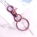 Matte dark pink metal lobster clasp keychain with swivel ring on marble background - Coffee
