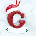 Close-up of sparkling red letter G ornament with a 3D Santa hat for Christmas trees - Letter G