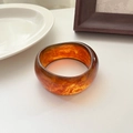 Wide irregular resin bangle with amber tortoiseshell pattern in polished finish - Red Amber